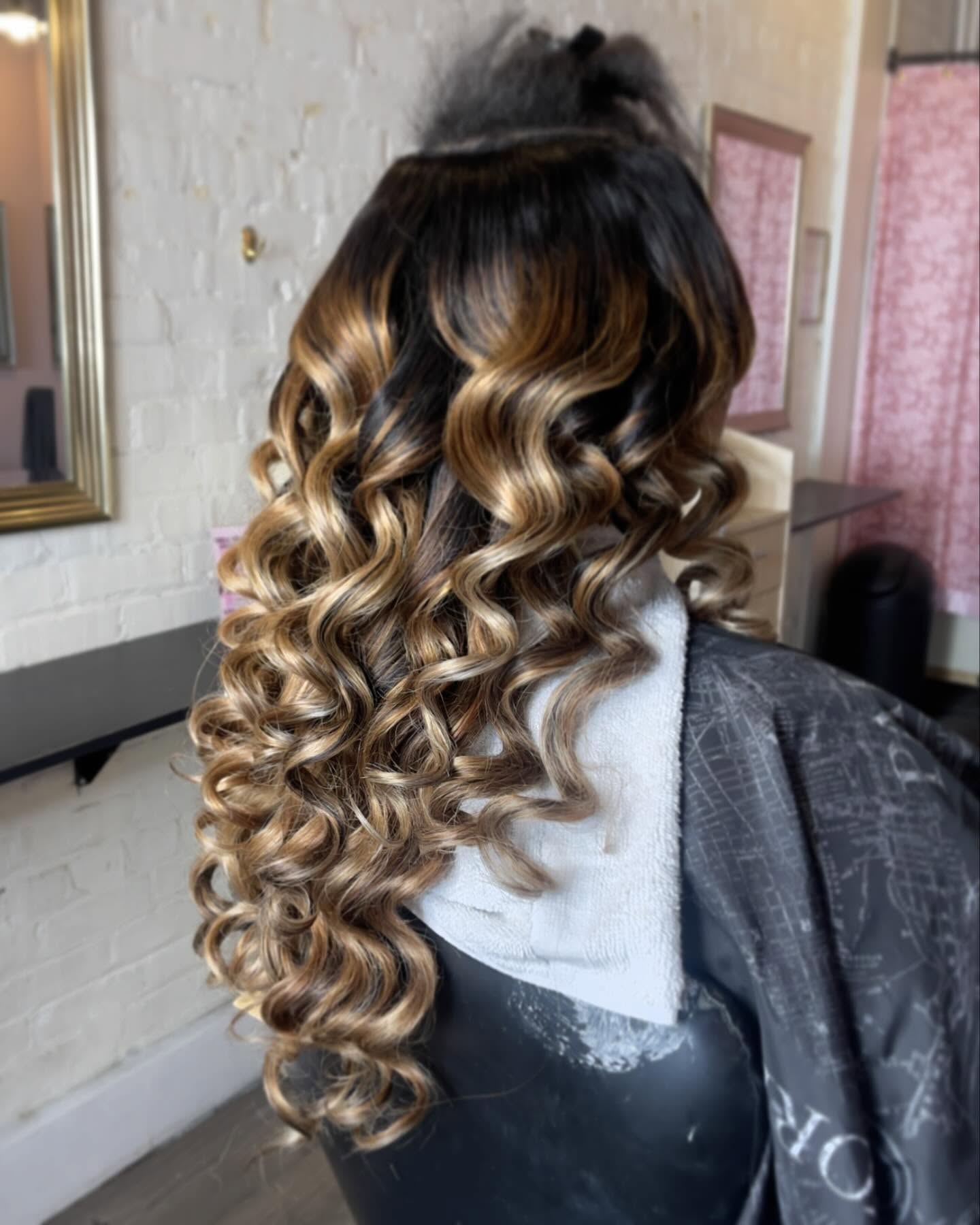 woman with wavy, ombre hair in a salon setting